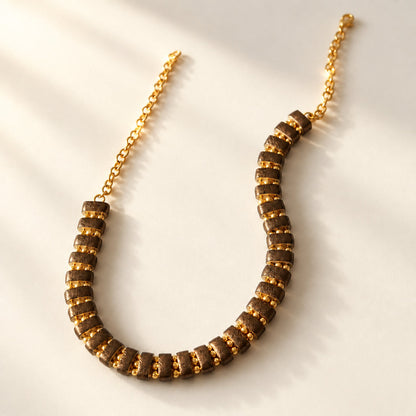 Noupelle Sienna choker featuring upcycled brown leather segments and 18K gold-plated brass beads on a gold chain.
