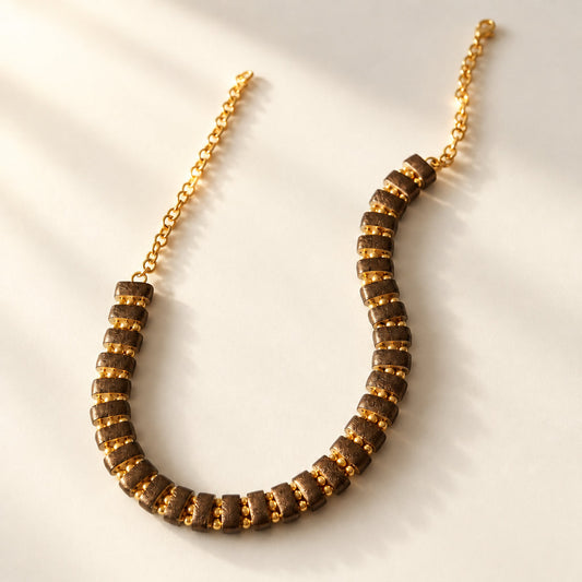 Noupelle Sienna choker featuring upcycled brown leather segments and 18K gold-plated brass beads on a gold chain.