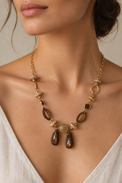 Noupelle Vienne neckpiece featuring 18K gold-plated brass, freshwater pearls, faceted stones, and upcycled leather.