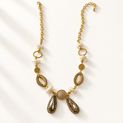 Noupelle Vienne neckpiece featuring 18K gold-plated brass, freshwater pearls, faceted stones, and upcycled leather.